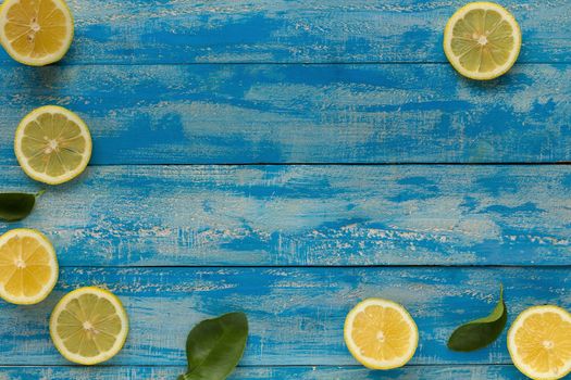 Yellow lemon on a blue wooden background. Top view.