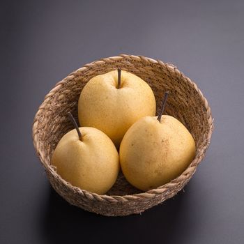 Chinese pear fruits on black background.