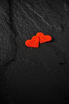 Red heart written love words placed on black stone floor.