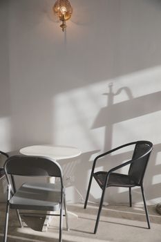 Wooden table and chairs with lamp on wall