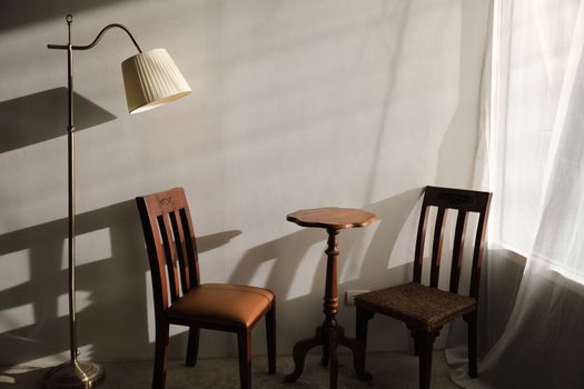 Wooden table and chairs with lamp on wall