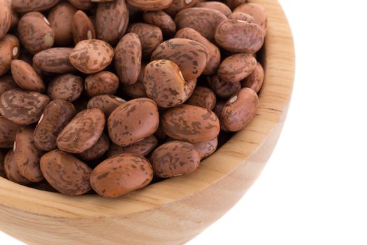 pinto beans  in a wooden bowl isolated on a white background