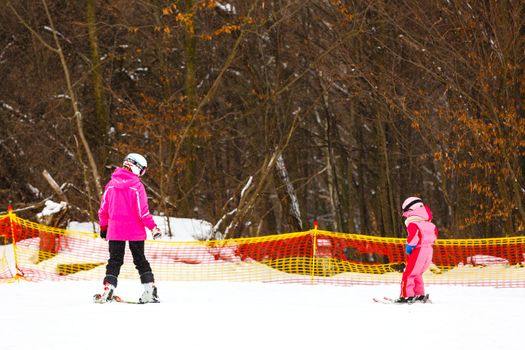 Ski lesson, little girl skiing with an instructor