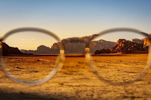 View at the Wadi Rum desert in Jordan through glasses during a nice sunset with clear sky. Travel, tourism and adventure.