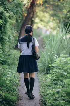 Portrait of asian japanese school girl costume looking at park outdoor film vintage style