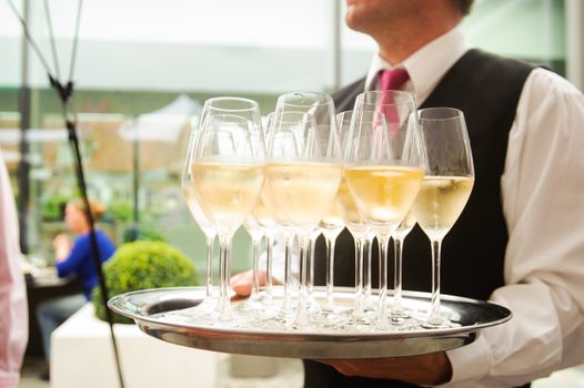 Waiter waiting with a plate full of glasses Champagne
