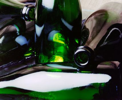 Closeup of a group of empty wine and champagne bottles with transparancy and reflection
