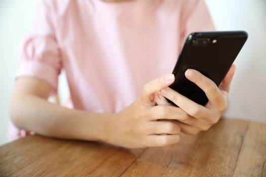 Female hand with smartphone trading stock online in coffee shop , Business concept