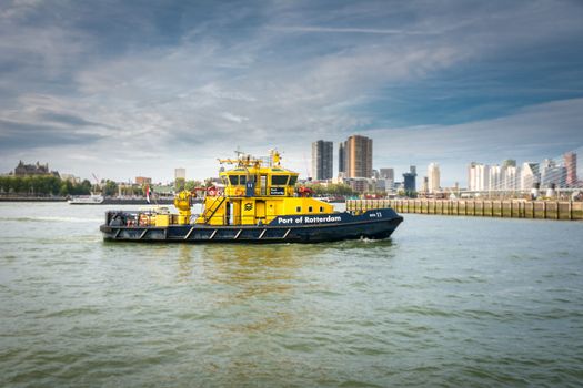 Rotterdam, Netherlands, September 2019: port authority vessel on patrol in the harbor at Wilhelminapier. Skyline of Rotterdam in the background