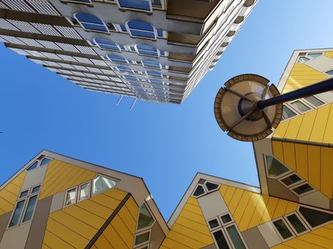 Rotterdam, Netherlands, September 2019: Low angle view of the Cube houses (Kubuswoningen) and Blaaktoren (Het Potlood) architecture, both designed by architect Piet Blom