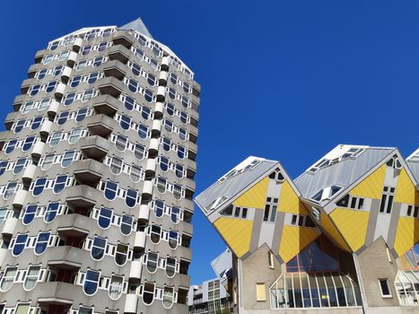 Rotterdam, Netherlands, September 2019: Dutch architecture. Piet Blom's cube houses (kubuswoningen) and Blaaktoren (Het Potlood, or Pencil tower) in one image. Blue sky and sunny day in Rotterdam.