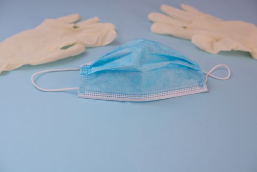 Mask and latex gloves isolated against blue background