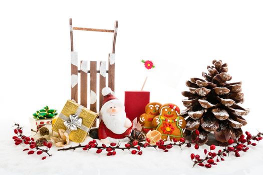Close up of Santa sitting on wooden horse sledge holding gift and presents - white and red christmas background