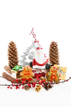 Close up of Santa sitting on wooden horse sledge holding gift and presents - white and red christmas background