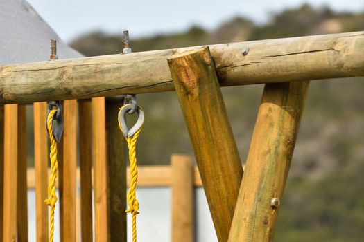 Wooden log frame structure with yellow swing ropes in playground, Mossel Bay, South Africa