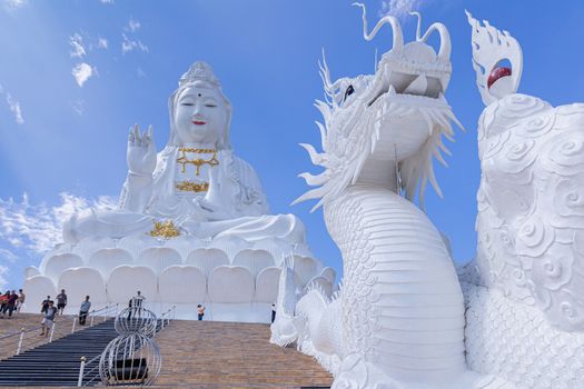 Guan Yin statue and dragon statue with blue sky and clouds sky at Huay Pla Kang Temple, Chiangrai, Thailand.