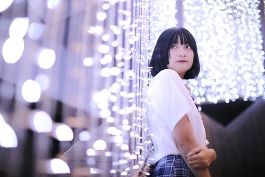 Portrait of asian japanese school girl costume looking in urban night with bokeh