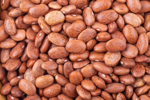 pinto beans in a wooden bowl isolated on a white background.