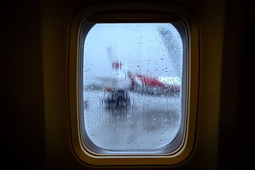 Raindrops on the porthole of an airplane.