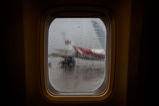 Raindrops on the window glass of an airplane.