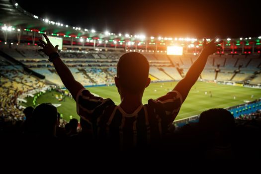 Football fans support team on crowded soccer stadium