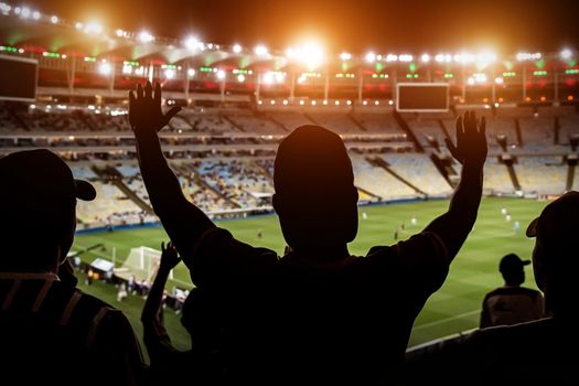 Football fans support team on crowded soccer stadium