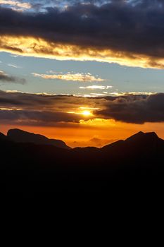 Sunset. The sun above the line of mountains