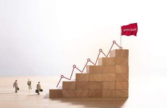 Businessman walking up stairway to the top of wood block mountain, Business concept growth and the path to success.