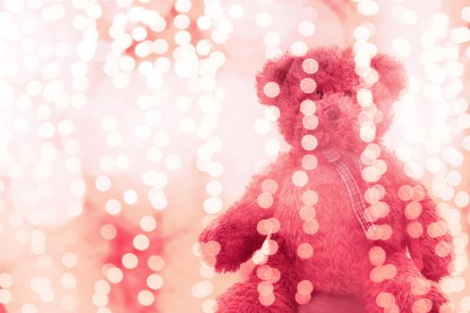Teddy bear doll in Lighting line bokeh pink bright for Christmas or happy new year Background, Bear Sitting lonely in glitter pink white background Blurred bokeh bright (Selective Focus)