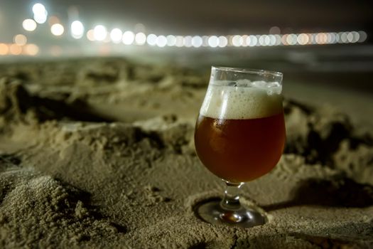 A glass of beer at Copacabana Beach in Rio De Janeiro, Brazil. Night lighting.