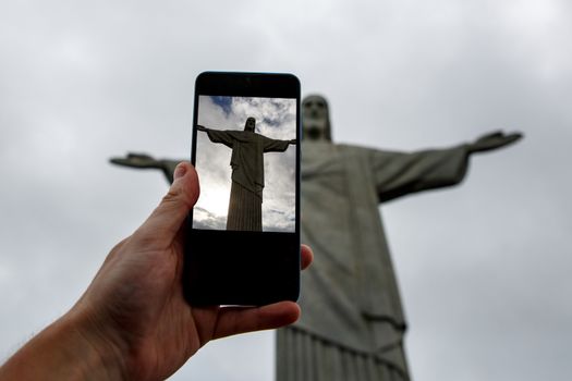 Rio de Janeiro, Brazil - 21.11.2019: Shooting by smartphone Christ the Redeemer Statue in Rio de Janeiro, Brazil