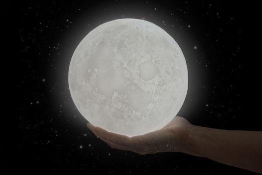 The moon hold by a human hand with stars.