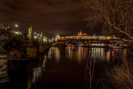 Night view of Charles Bridge and Mala Strana in Prague during winter.