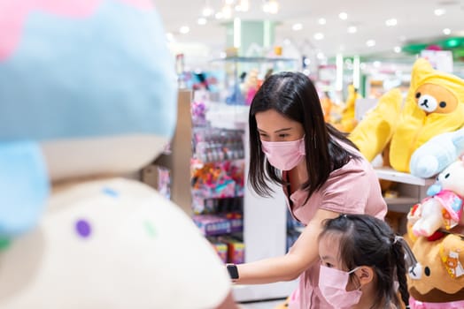 Editorial: Central Bangna Bangkok City, Thailand, 6th Jun 2020. An Asian woman and daughter shopping in the toy store after opening lockdown with pink mask and social distancing.