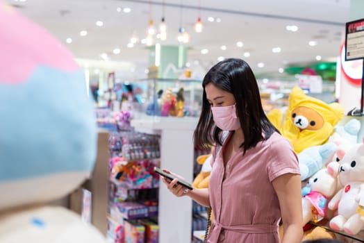 Editorial: Central Bangna Bangkok City, Thailand, 6th Jun 2020. An Asian woman shopping in the toy store after opening lockdown with pink mask and social distancing.