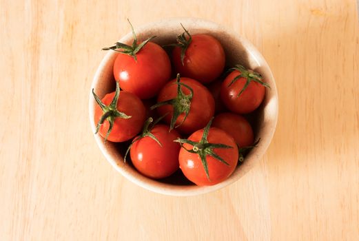 Red tomato on a cutting board wiht wooden background.