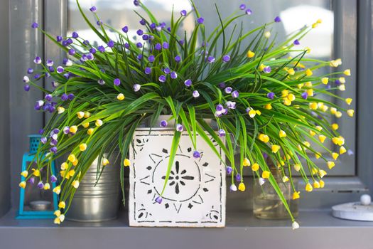 Decorative artificial flowers on the window sill