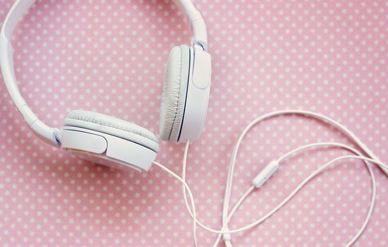 White headphones on pink background