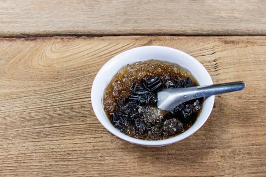 Grass Jelly put glass bowls and ice is thai dessert place on wooden table, Top view.