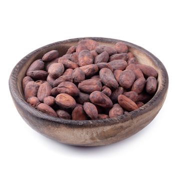 Cocoa fruit in a wooden bowl, raw cacao beans isolated on a white background.