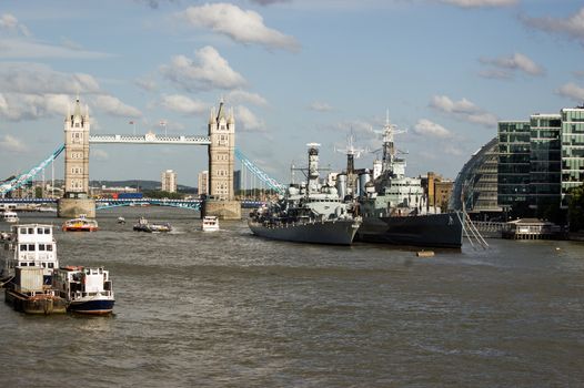 London, UK - July 6, 2011:  View of the River Thames from London Bridge, City of London. Tower Bridge in the background with the naval ships HMS Portland and HMS Belfast moored towards the centre.