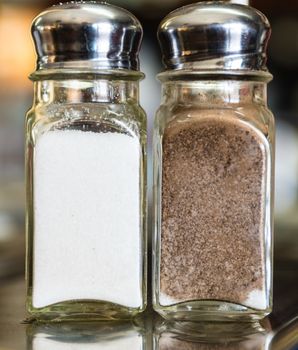 A salt and pepper shakers on a marble table.