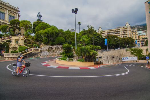 A cyclist riding around a hairpin turn from the Monaco Gran Prix Race Track in the South of France