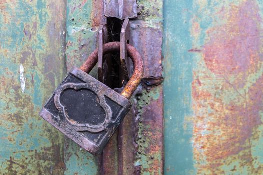 Old steel padlock securely locks the hangar gate