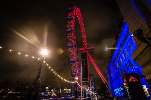 The London Eye illuminated at night in red