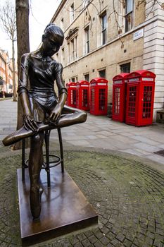 Some traditional red telephone boxes and a statue in London
