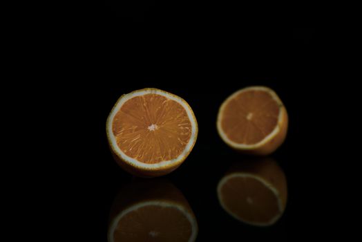 two halves of whole lemon on a black background with copy space