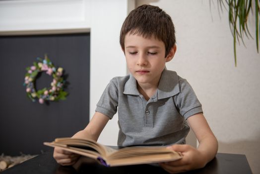 A boy without expressed interest reads a book