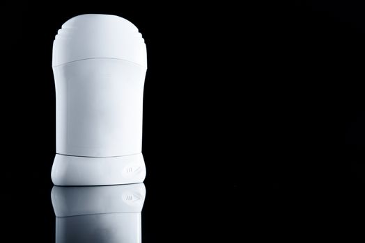 White antiperspirant deodorant standing on black background. Skin care concept with copy space