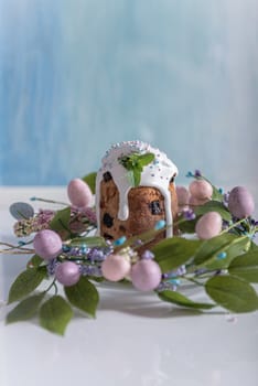 Easter cake in the center of a wreath of spring flowers on a blue vintage background